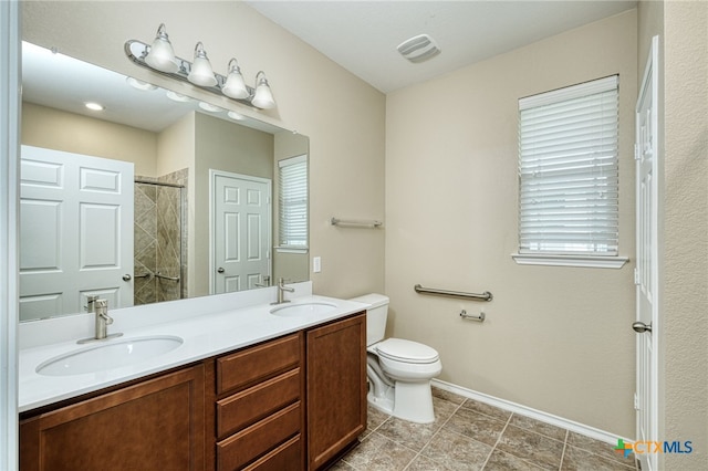 bathroom featuring a shower, vanity, and toilet