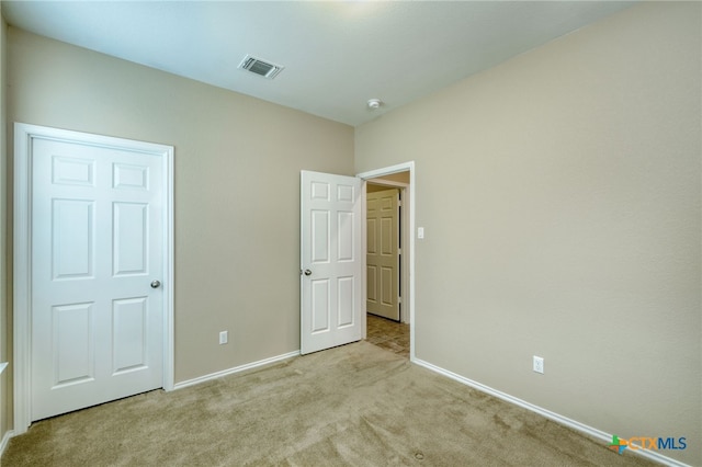 unfurnished bedroom featuring light carpet