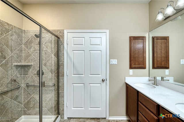 bathroom featuring a shower with door and vanity