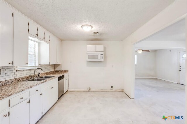 907 Curry Ave, Copperas Cove, TX 76522 - kitchen featuring stainless steel dishwasher, white microwave, a sink, decorative backsplash, and white cabinets