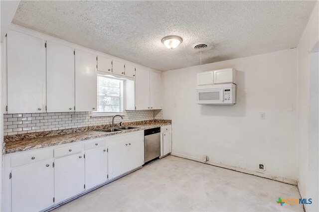 907 Curry Ave, Copperas Cove, TX 76522 - kitchen featuring white microwave, dishwasher, a sink, a textured ceiling, and decorative backsplash