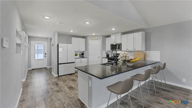 kitchen with sink, kitchen peninsula, appliances with stainless steel finishes, and white cabinetry