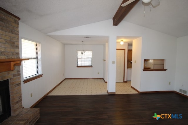 unfurnished living room featuring lofted ceiling with beams, hardwood / wood-style flooring, ceiling fan, and a brick fireplace