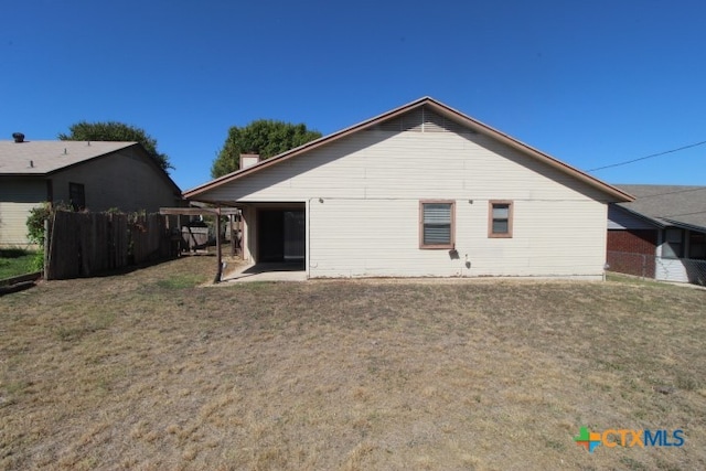 rear view of house featuring a patio and a yard