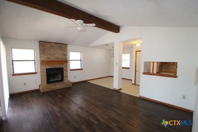 unfurnished living room featuring a brick fireplace, a wealth of natural light, wood-type flooring, and vaulted ceiling with beams