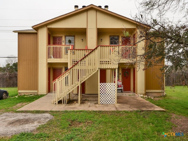 rear view of property featuring stairs, a porch, and a yard