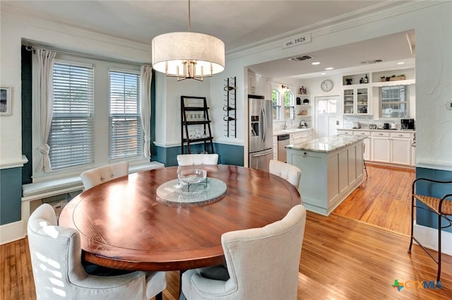 406 S Liberty St, Victoria, TX 77901 - dining space with light wood-style floors, an inviting chandelier, ornamental molding, and visible vents