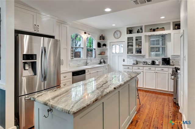406 S Liberty St, Victoria, TX 77901 - kitchen featuring white cabinets, open shelves, a center island, a sink, and stainless steel appliances
