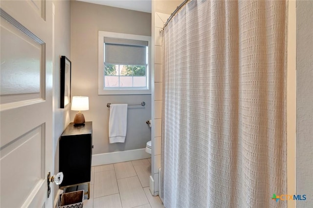 406 S Liberty St, Victoria, TX 77901 - full bathroom with toilet, a shower with shower curtain, tile patterned flooring, and baseboards