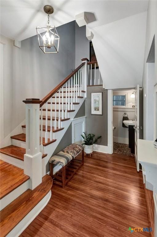 406 S Liberty St, Victoria, TX 77901 - staircase with wood finished floors, a notable chandelier, lofted ceiling, and baseboards