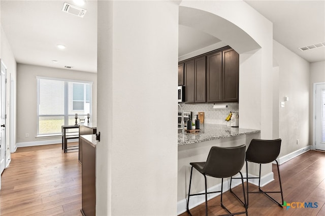 5712 Red Fish Ct, Belton, TX 76513 - bar area featuring light wood-type flooring, backsplash, and baseboards