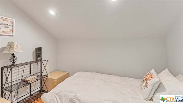 bedroom featuring wood-type flooring and vaulted ceiling