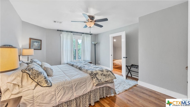 bedroom featuring ensuite bathroom, hardwood / wood-style floors, and ceiling fan