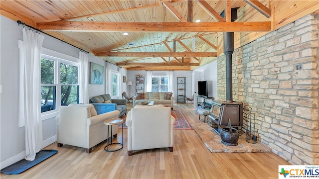 living room featuring a wood stove, light wood-type flooring, a healthy amount of sunlight, and wooden ceiling