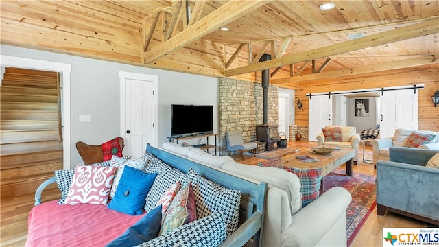 living room featuring wood-type flooring, a wood stove, a barn door, wooden ceiling, and lofted ceiling with beams