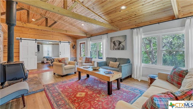 living room featuring a barn door, wooden ceiling, vaulted ceiling with beams, and light hardwood / wood-style flooring