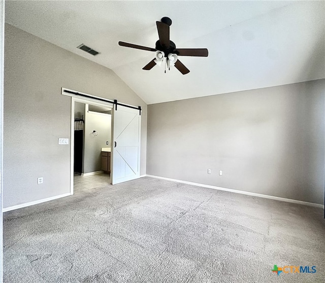 214 Yellowstone Dr, Victoria, TX 77904 - unfurnished bedroom with a barn door, vaulted ceiling, carpet floors, baseboards, and a ceiling fan