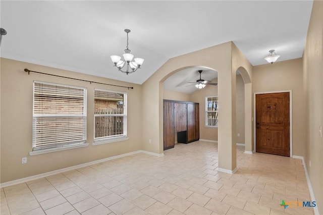 foyer entrance featuring light tile patterned floors, baseboards, arched walkways, and vaulted ceiling