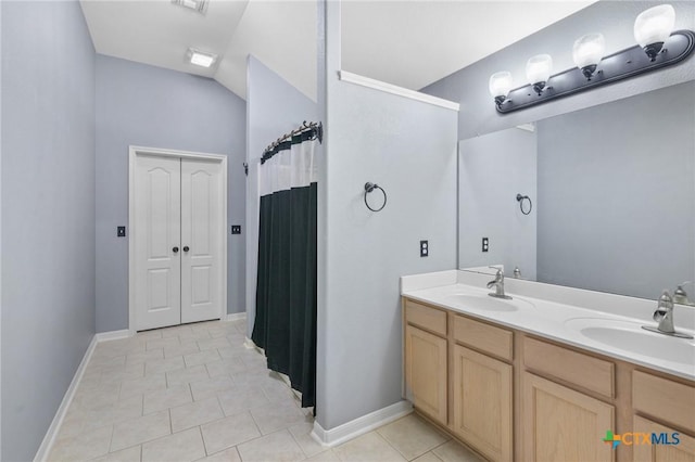 214 Yellowstone Dr, Victoria, TX 77904 - full bathroom featuring tile patterned floors, double vanity, lofted ceiling, a shower with curtain, and baseboards