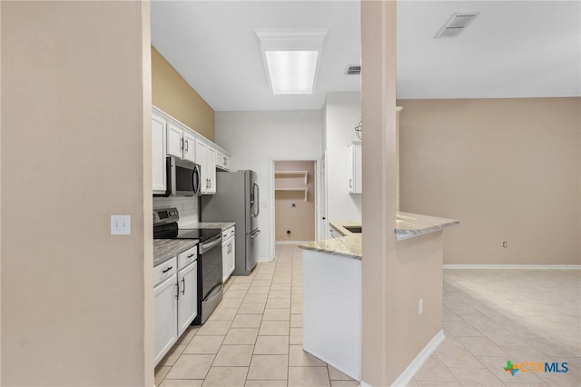 214 Yellowstone Dr, Victoria, TX 77904 - kitchen featuring stainless steel appliances, light tile patterned floors, white cabinets, backsplash, and a peninsula