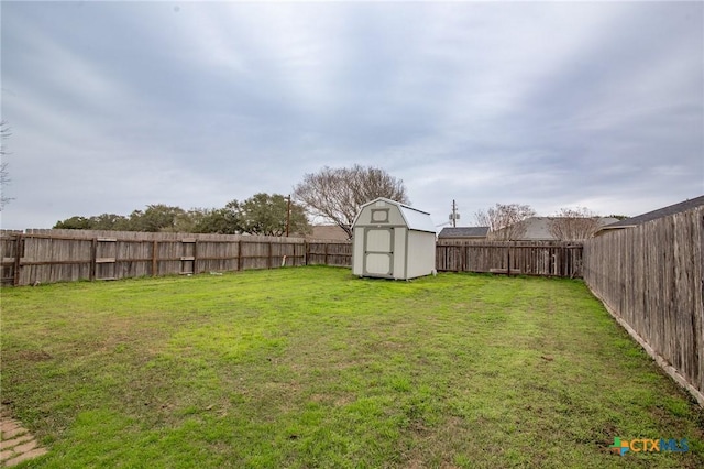 view of yard with an outbuilding, a storage unit, and a fenced backyard