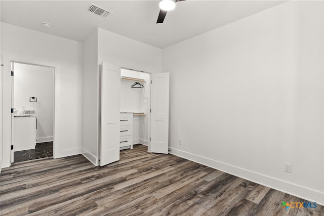 unfurnished bedroom with dark hardwood / wood-style floors, a closet, and ceiling fan