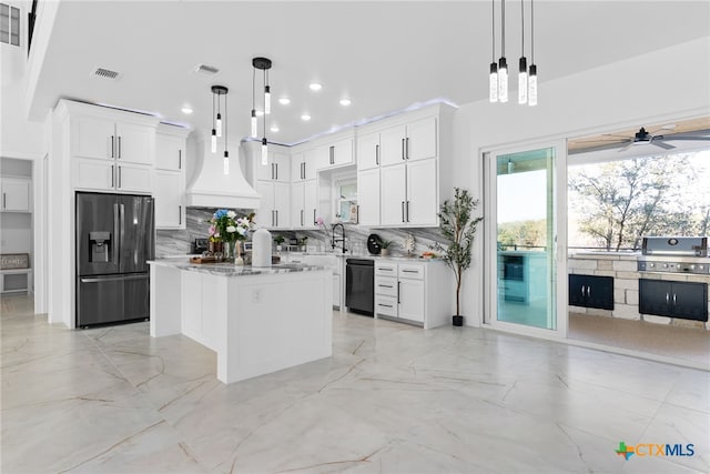 kitchen with hanging light fixtures, white cabinets, black appliances, and a kitchen island