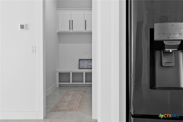 room details with white cabinets and stainless steel fridge