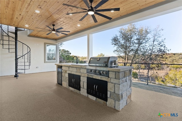 view of patio featuring ceiling fan, an outdoor kitchen, and a grill