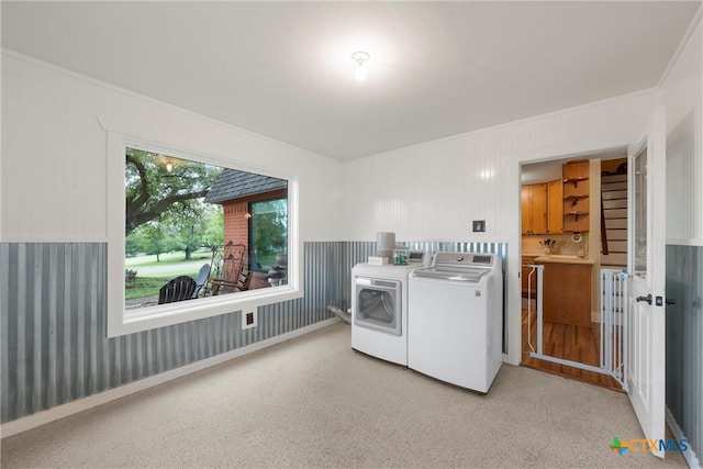 laundry room featuring crown molding, washer and clothes dryer, and laundry area