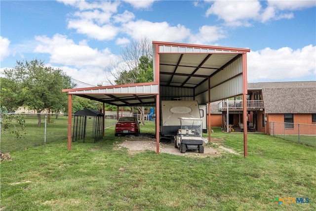 view of vehicle parking with fence, driveway, and a detached carport