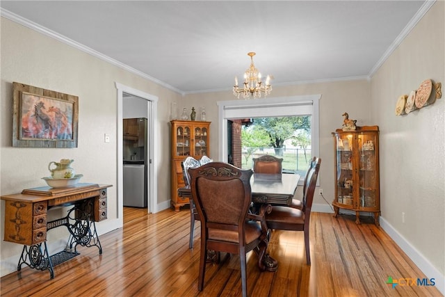 dining area with light wood finished floors, crown molding, baseboards, and a notable chandelier