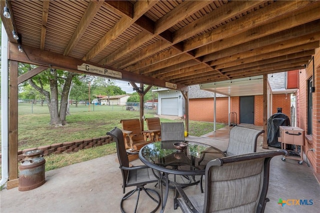 view of patio with fence, an outdoor structure, a storage shed, and outdoor dining space