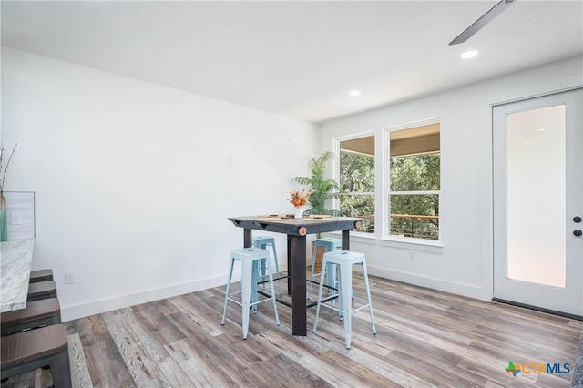 dining area featuring light wood-style flooring, baseboards, and recessed lighting