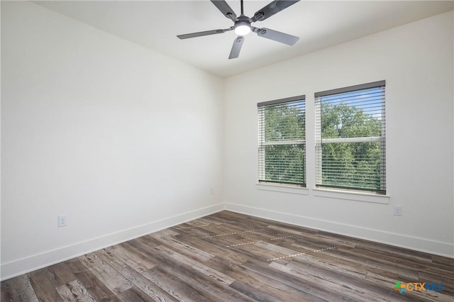 empty room featuring a ceiling fan, baseboards, and dark wood-type flooring