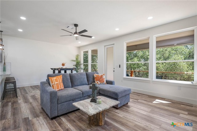 living room featuring recessed lighting, visible vents, baseboards, and wood finished floors