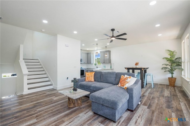 living area with dark wood-style floors, baseboards, stairway, and recessed lighting