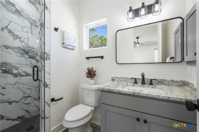 bathroom with a marble finish shower, baseboards, toilet, ceiling fan, and vanity