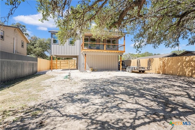 back of house with board and batten siding and a fenced backyard