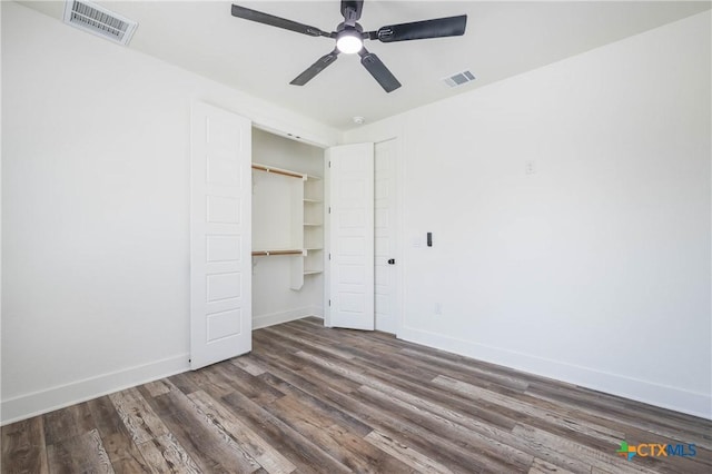 unfurnished bedroom with baseboards, visible vents, and dark wood-type flooring