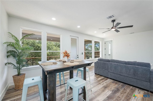 dining space with baseboards, wood finished floors, visible vents, and recessed lighting