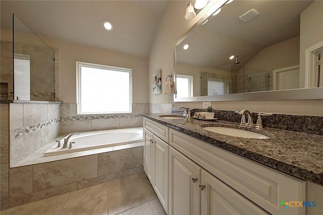 bathroom featuring vaulted ceiling, a wealth of natural light, vanity, and plus walk in shower