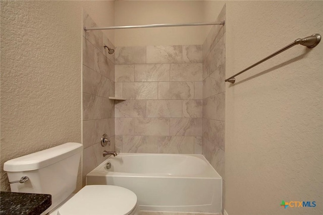 bathroom with tiled shower / bath and toilet