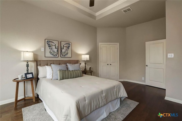 bedroom featuring dark wood-type flooring, ceiling fan, and a closet