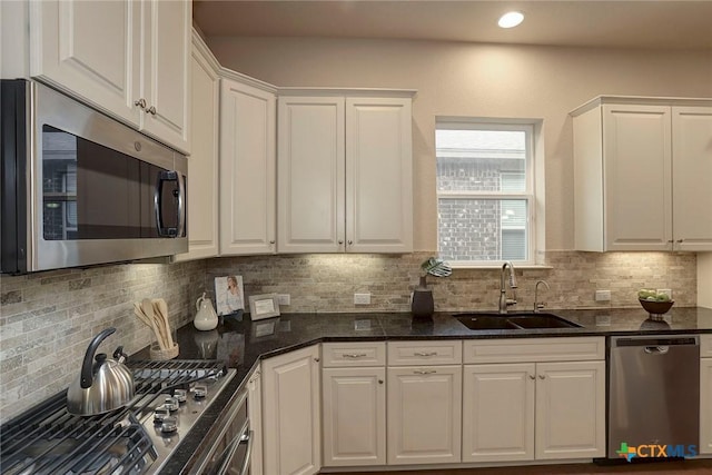 kitchen featuring backsplash, appliances with stainless steel finishes, sink, and white cabinets