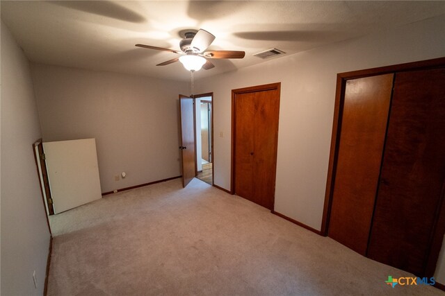 unfurnished bedroom with light colored carpet and ceiling fan