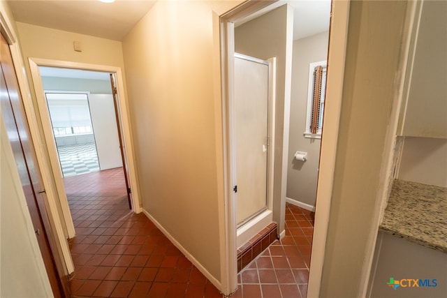 hall with dark tile patterned floors