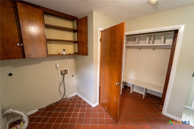 washroom with dark tile patterned flooring, electric dryer hookup, cabinets, and washer hookup