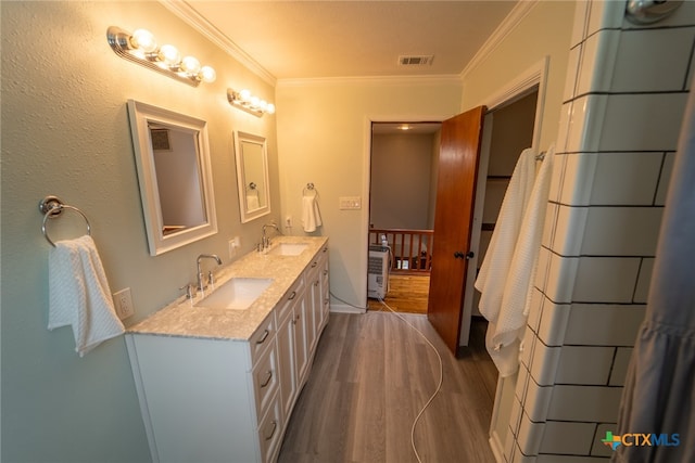 bathroom featuring wood-type flooring, vanity, and ornamental molding