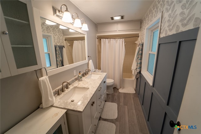 full bathroom featuring vanity, hardwood / wood-style flooring, toilet, and shower / tub combo